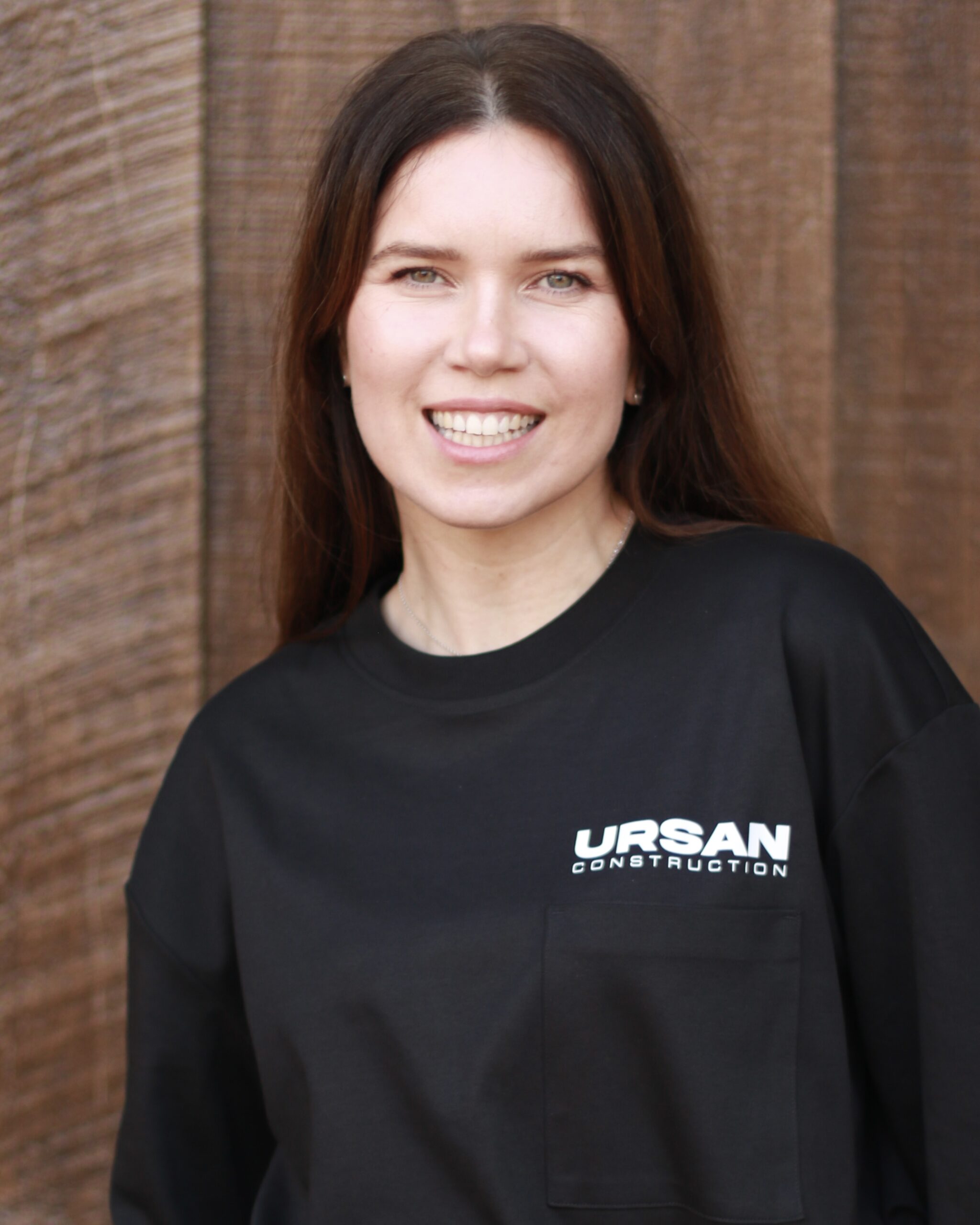 Female project coordinator at Ursan Construction in branded black apparel.