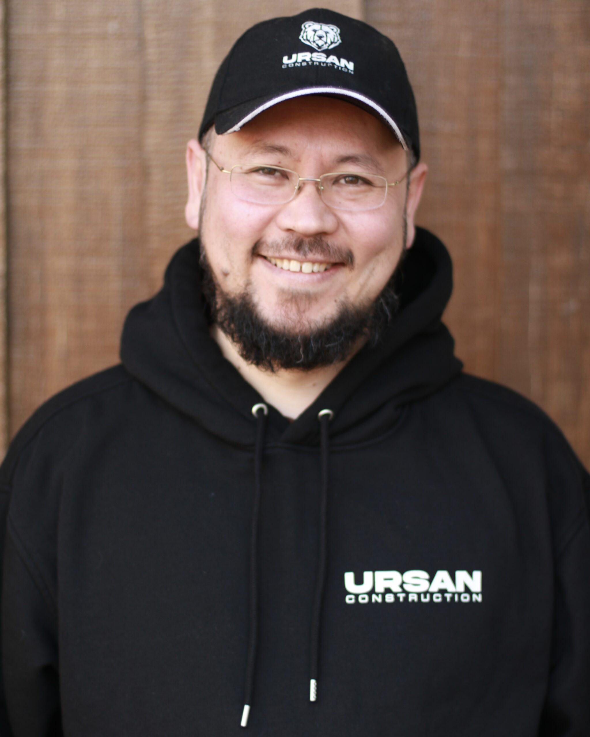 Professional team member from Ursan Construction wearing a black branded hoodie.