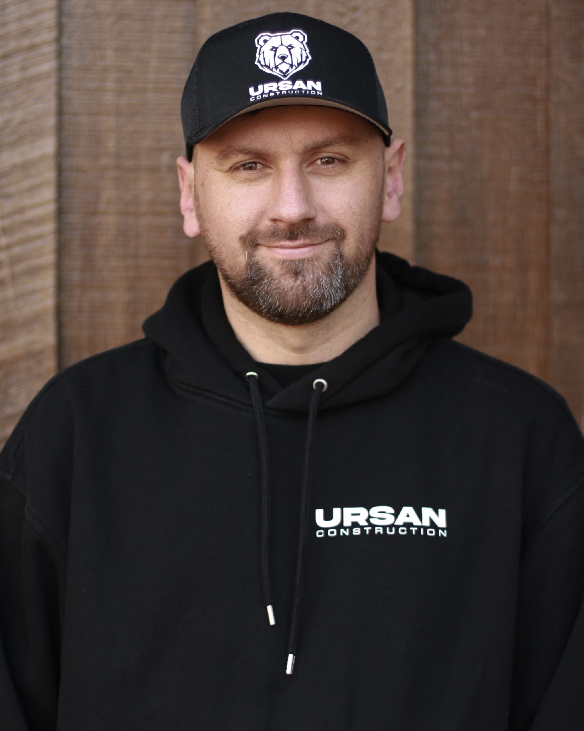 Lead remodeling expert at Ursan Construction wearing a branded cap.